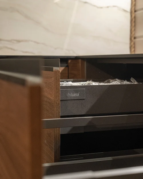 Открытые ящики Blum в открытой кухне с отделкой из темного дерева